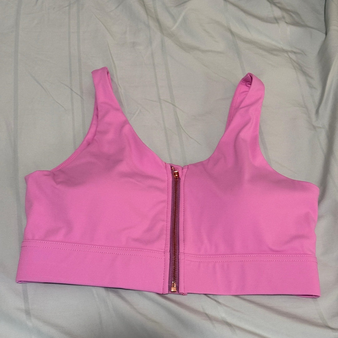 Pink sports bra with a zipper on a light gray background