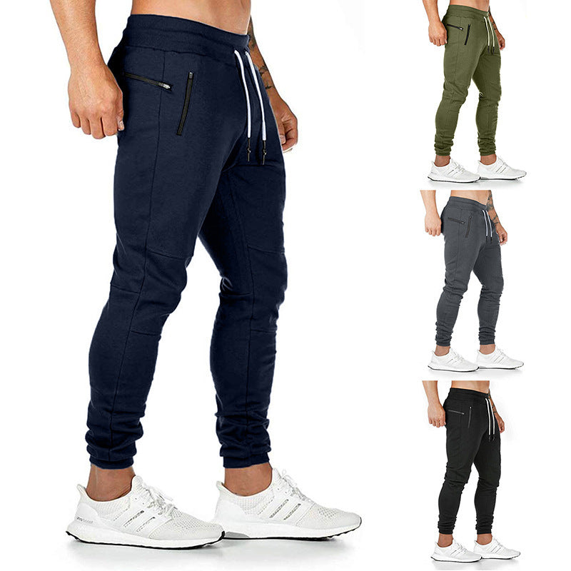 Navy jogger pants worn by a person with white sneakers, displayed against a white background.