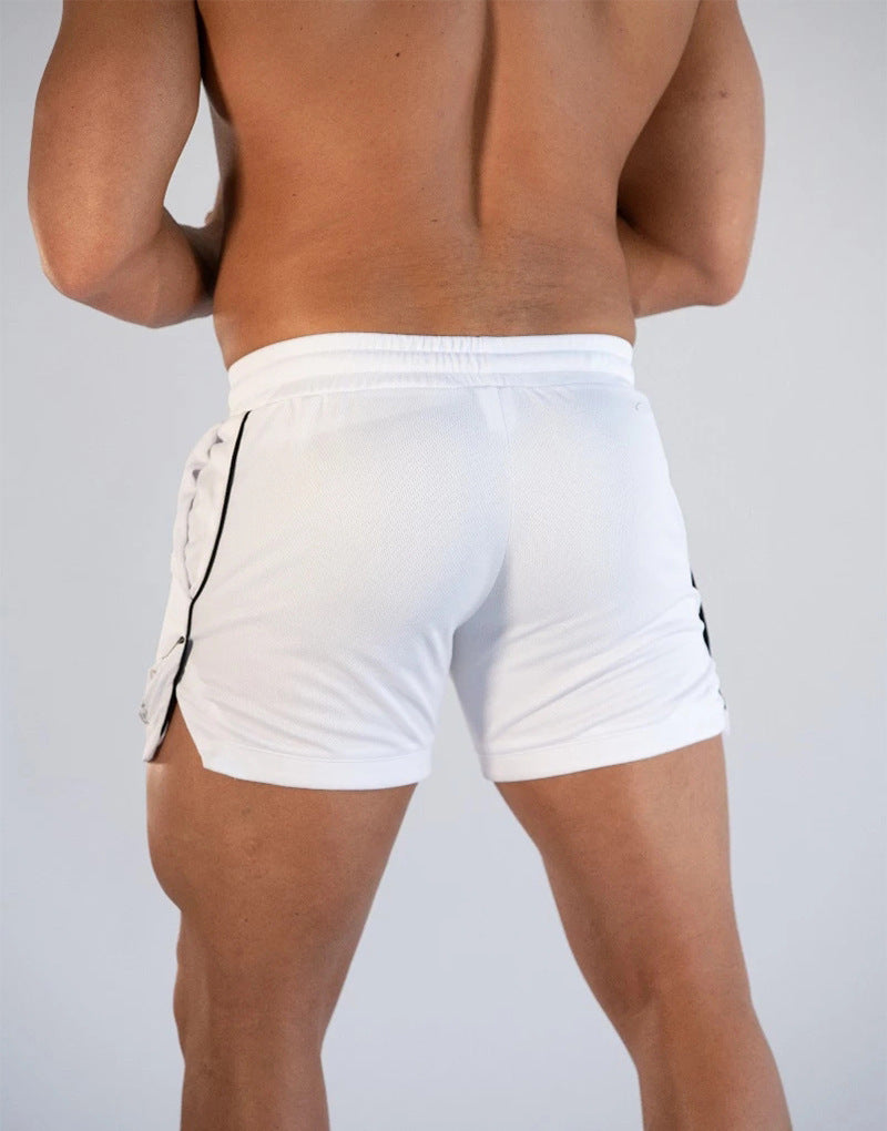 Person wearing white shorts with black accents on a plain background